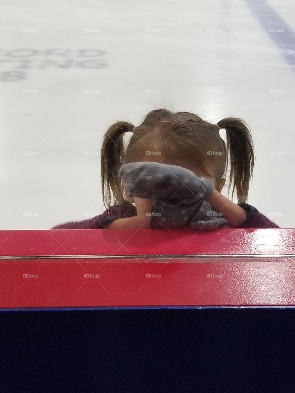 small girl playing peak a boo on ice testing mom