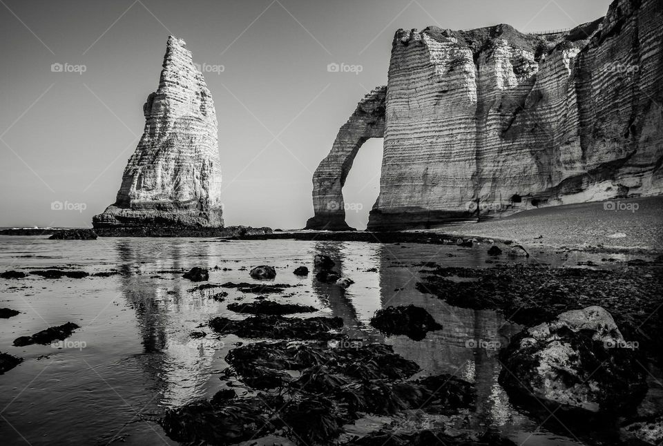Etretat cliff with reflection in water, black and white photography