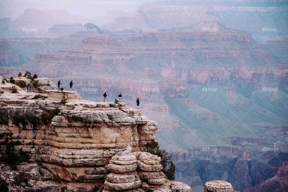 People standing at the edge of cliff at grand canyon