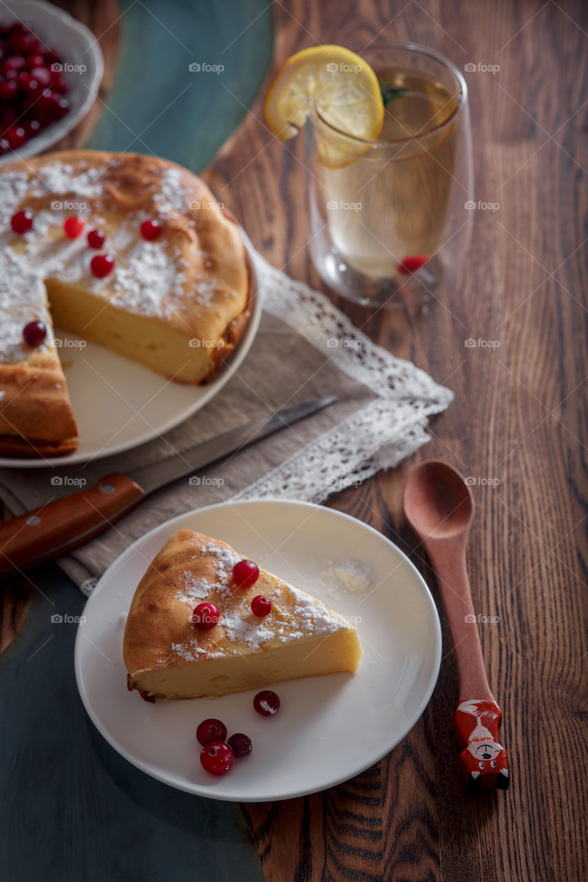 Cheesecake with cranberries and sugar on wooden background