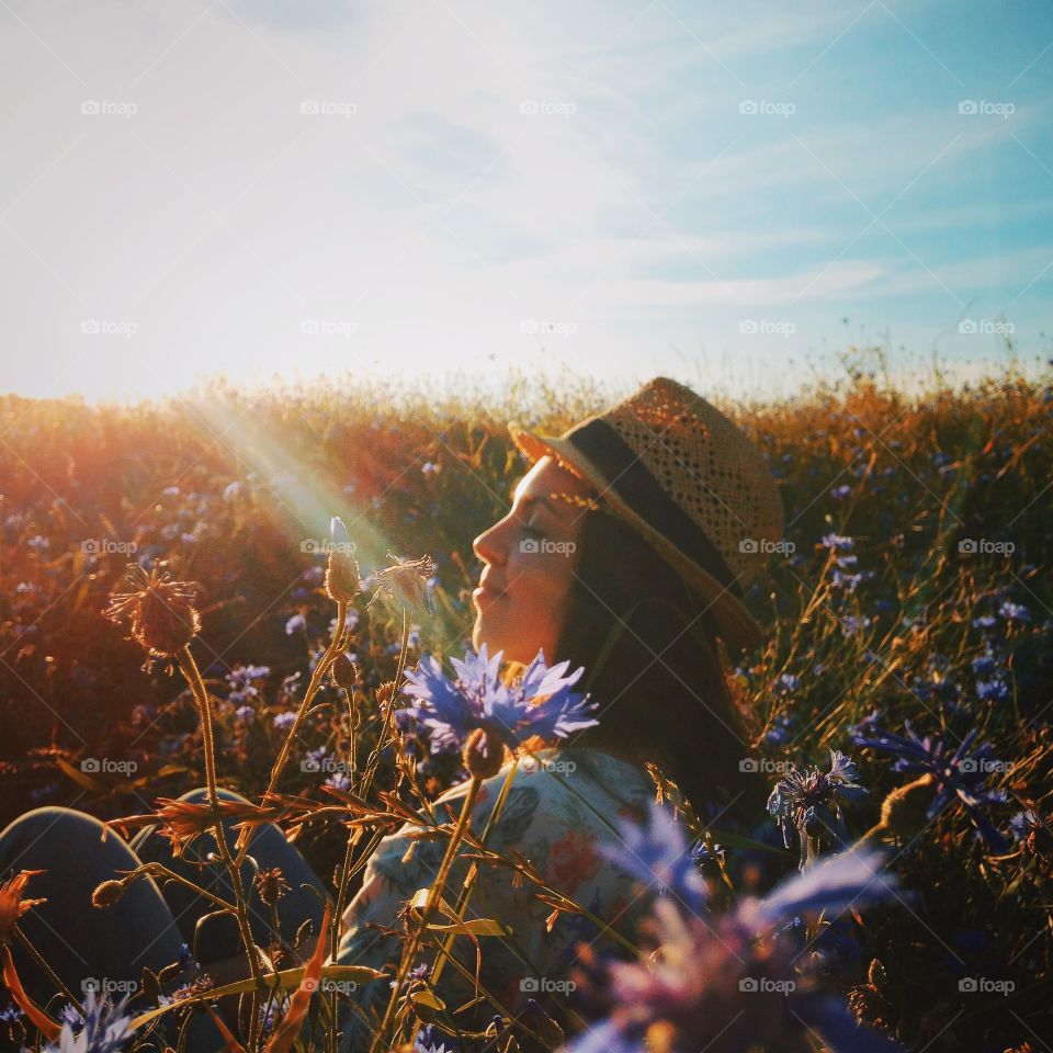 Woman in straw hat standing in the flower field