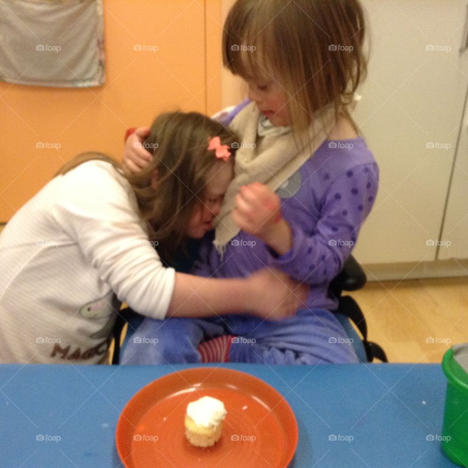 Biological sisters with Down syndrome, birthday hugs