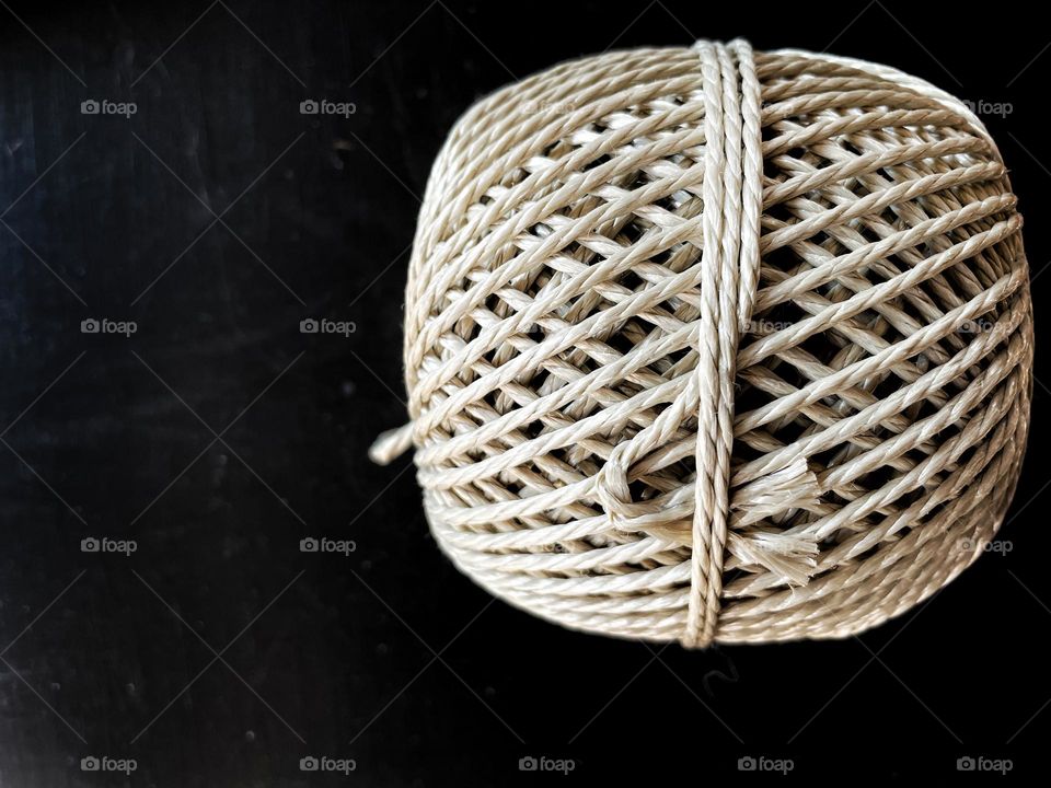 Close-up of a coiled string on black table 