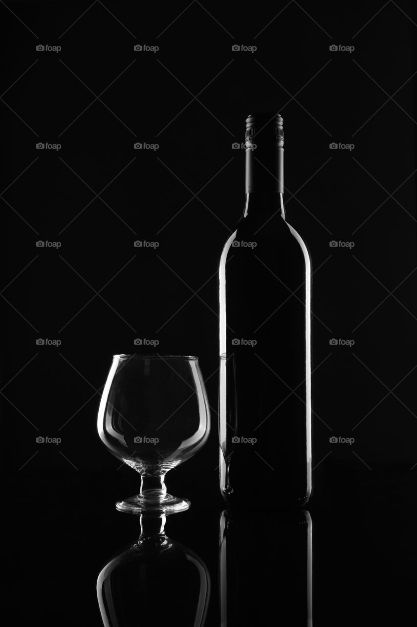 Wine bottle and glass on black background