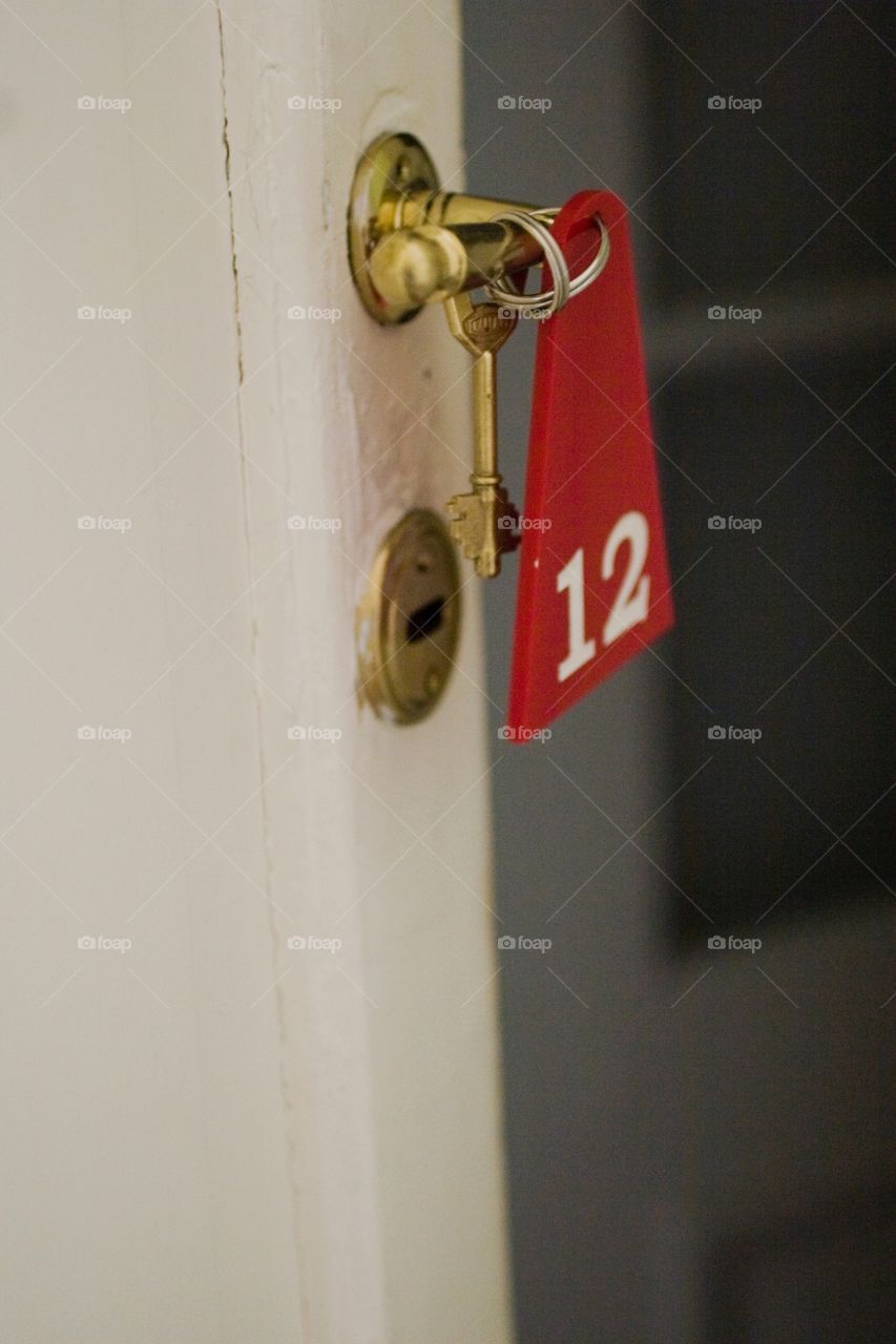 Hotel room door ajar with key hanging 