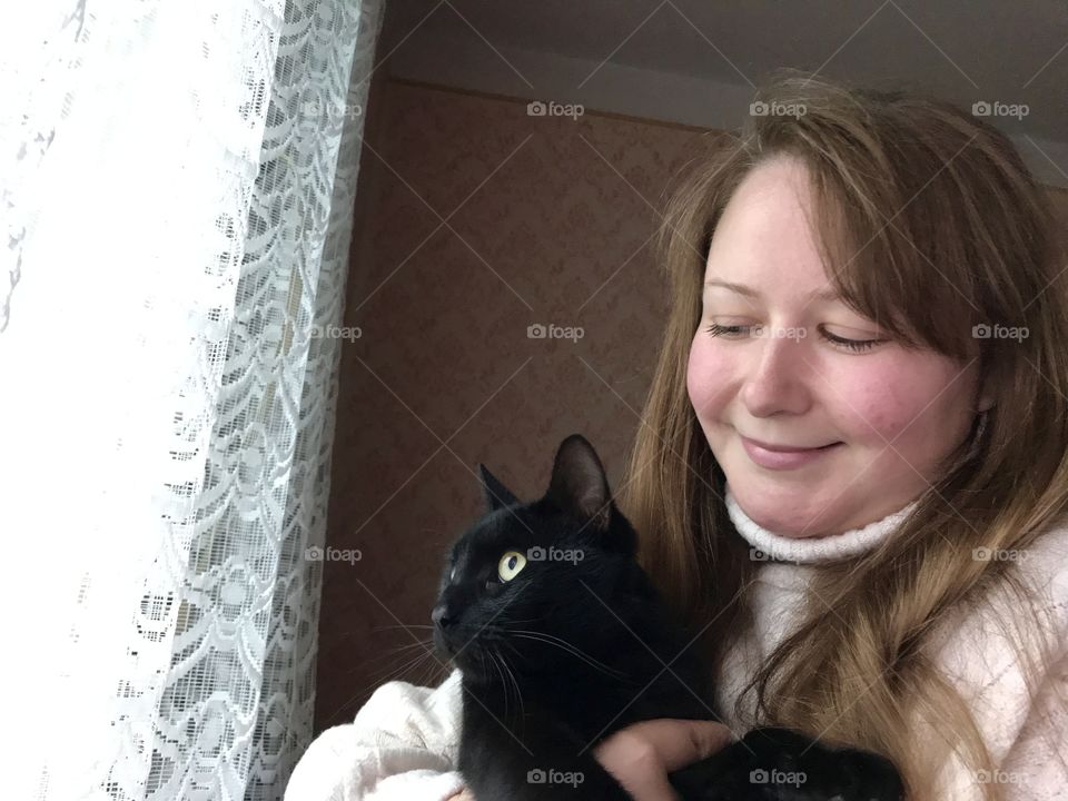 A girl and a black cat.