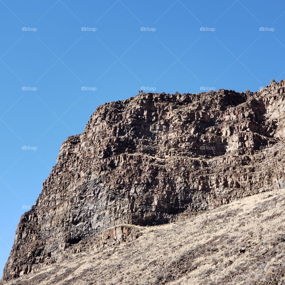 Hills along the Crooked River Highway made from andesite and basalt flows on a sunny fall day with clear blue skies in Central Oregon. 