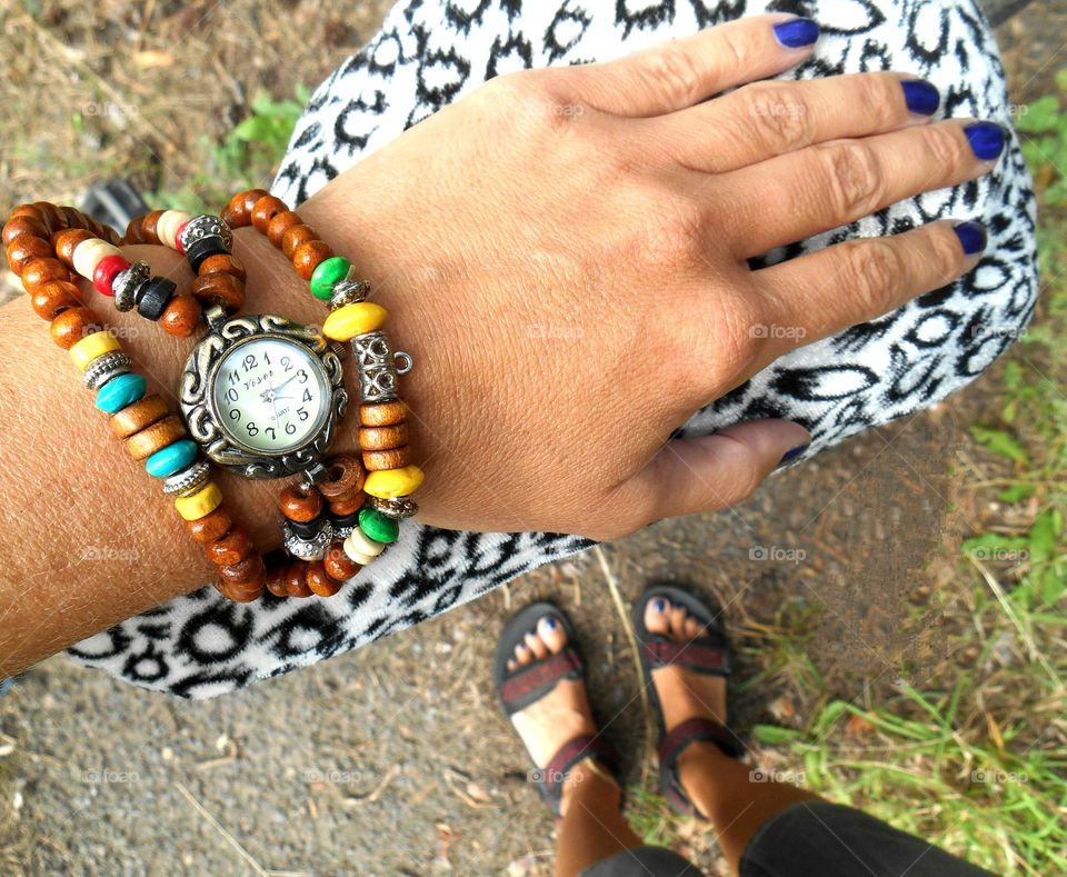 female hand with accessories beads clock