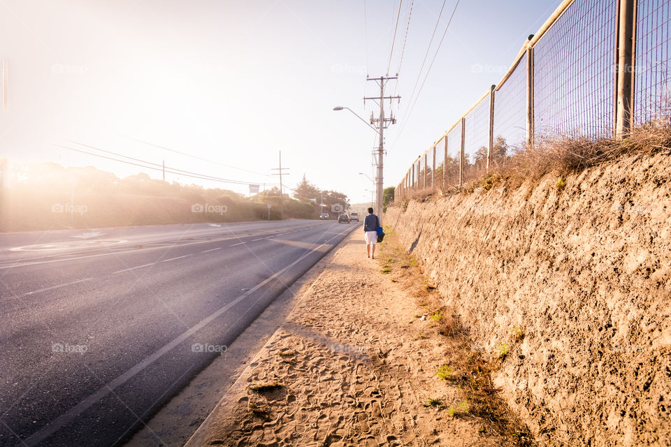 Man walking alone beside of the road leaving everything behind 