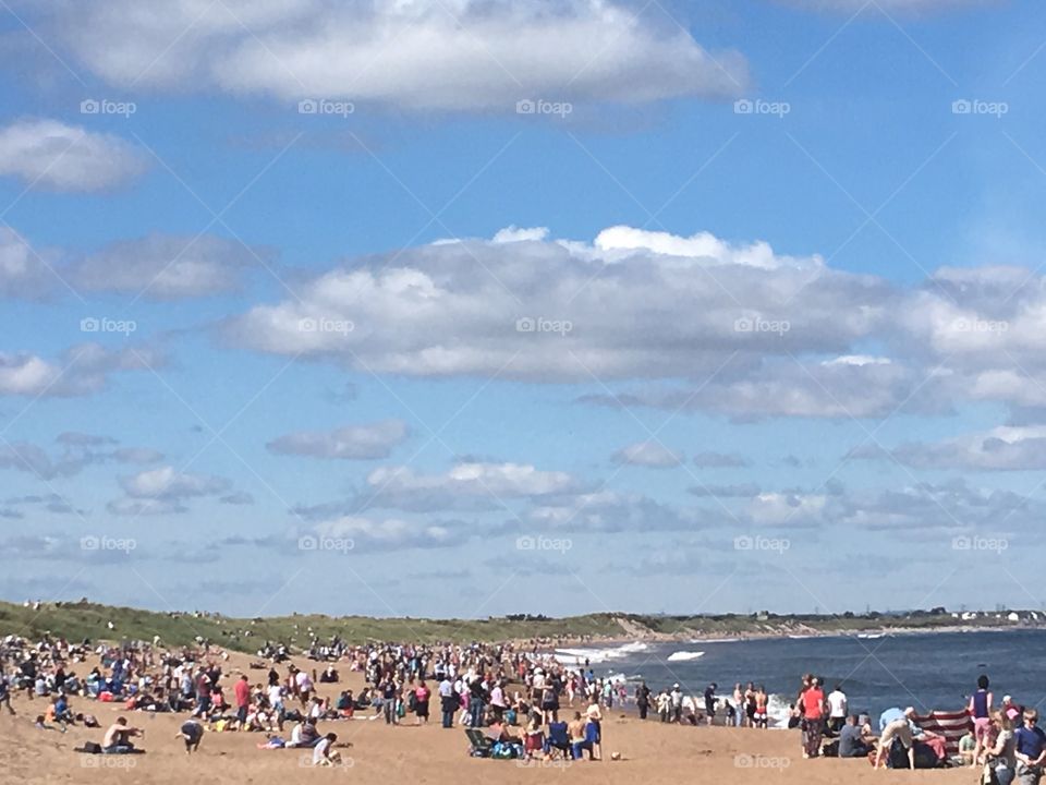 Hundreds of tourists gather on the beaches at Blyth to watch the start of the Tall Ships Race. The sunny day provides perfect conditions for both those on the beach, and the teams of sailors out running the boats.