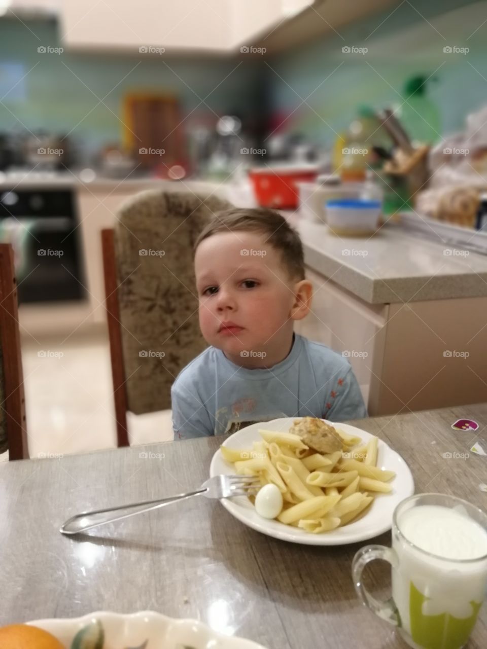Boy eating egg, spaghetti and meat