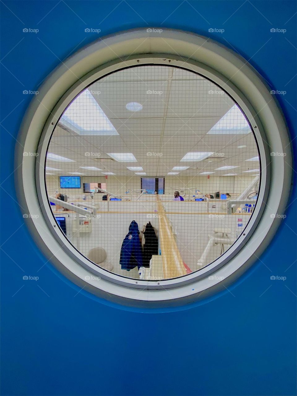 Through this naval style round porthole window we see the „NYU Kriser Dental Center“ on „East 24th St“ in „Manhattan“ at work. This dental school provides affordable services to people without insurance. 2023. Hypnotic Productions