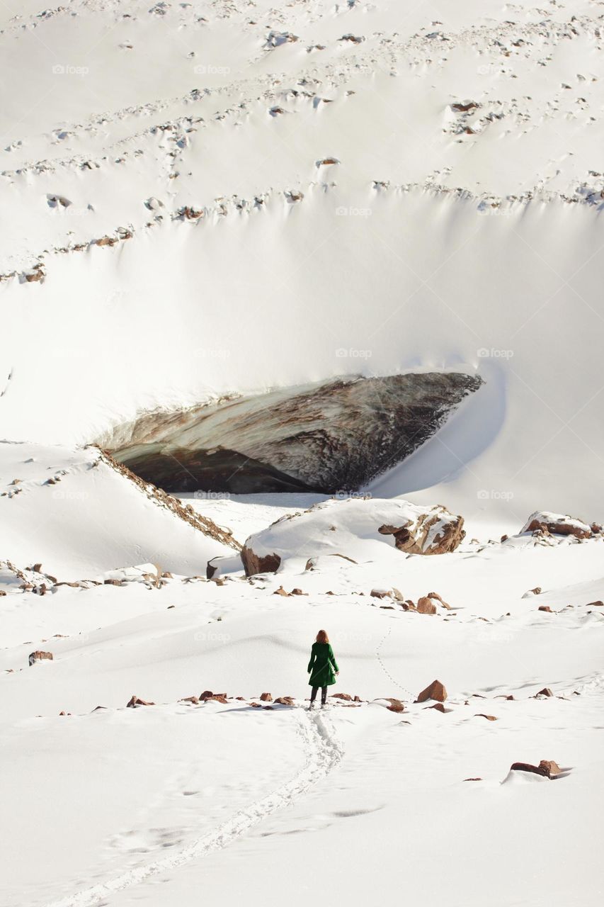 The girl stands among the snow on the glacier