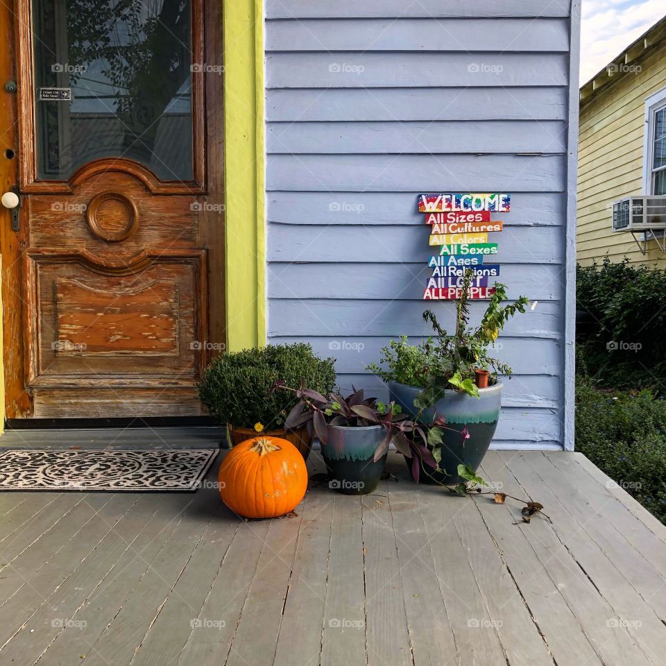 Inclusive welcome on a blue front porch.