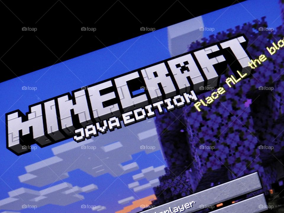 Video game photography taken of the game Minecraft from a gaming computer screen in a dark room at the start of the game showing the menu from the start.