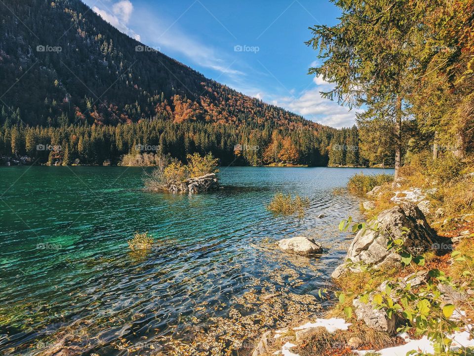 Scenic view of the snow covered Alps mountains reflected in the Italian lake close up