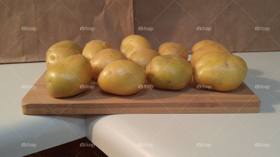 yellow potatoes on bamboo cutting board