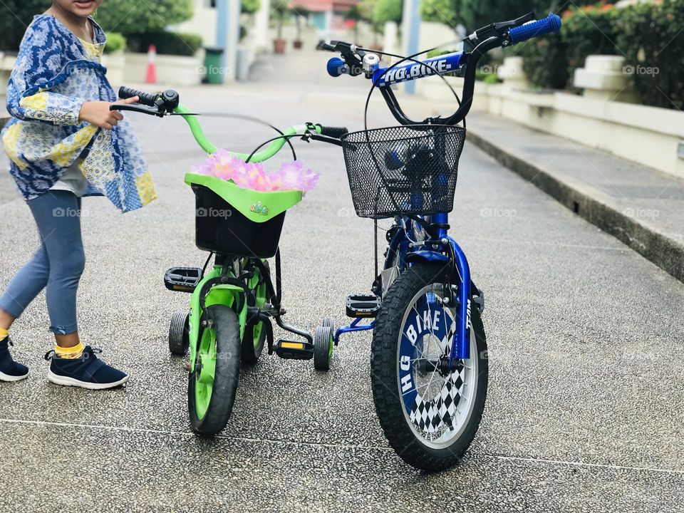 A blue and green cycle’s stand at middle of the road