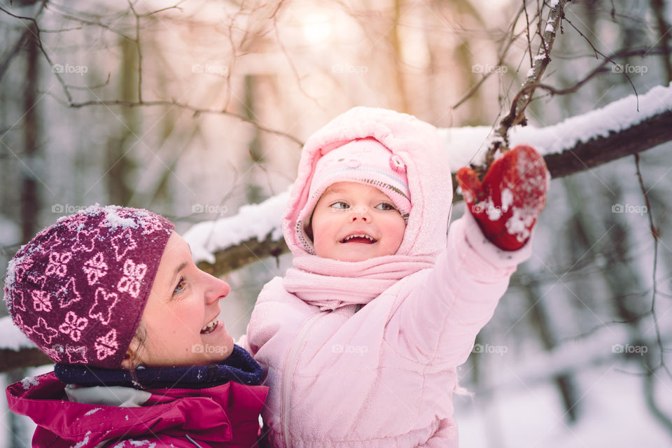 Mother spending time with her little daughter outdoors in the wintertime