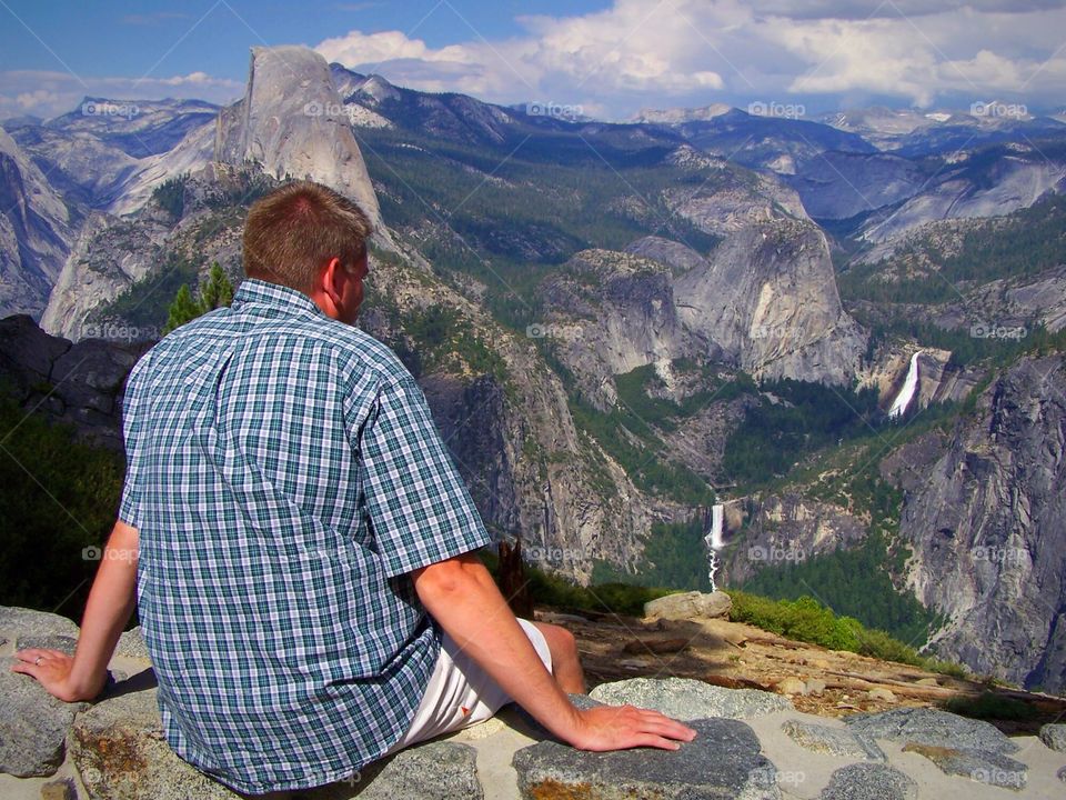 Man overlooking Yosemite Falls and Half-Dome from Glacier Point California; no handrails