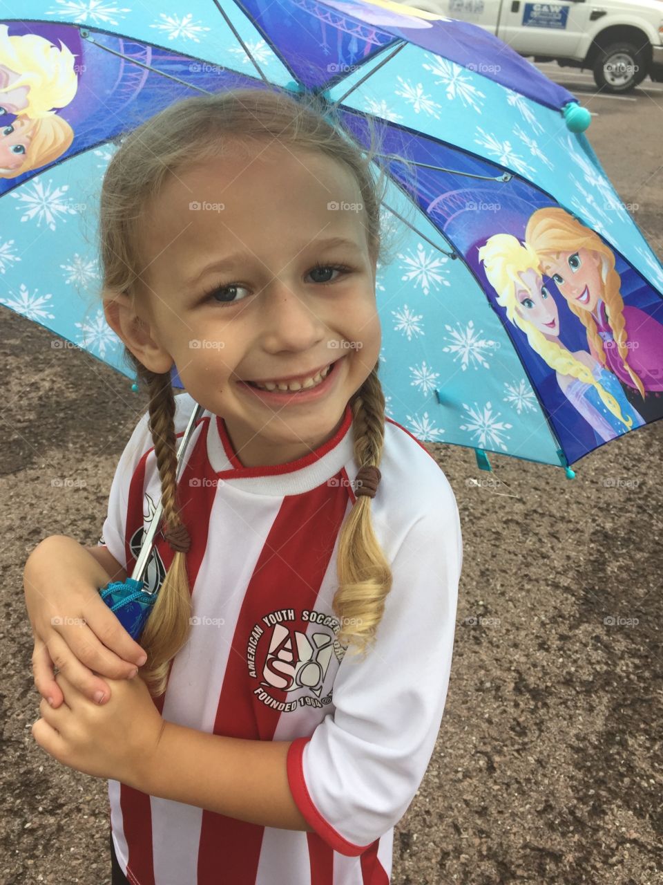 Happy little girl holding an umbrella. 