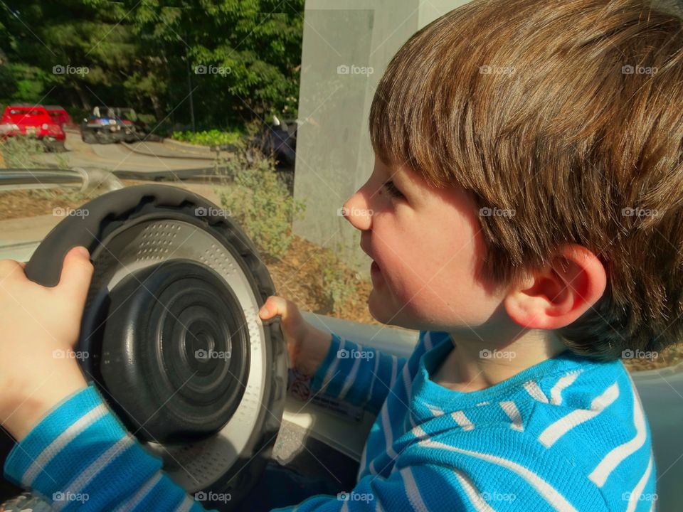 Young Boy Driving Toy Car