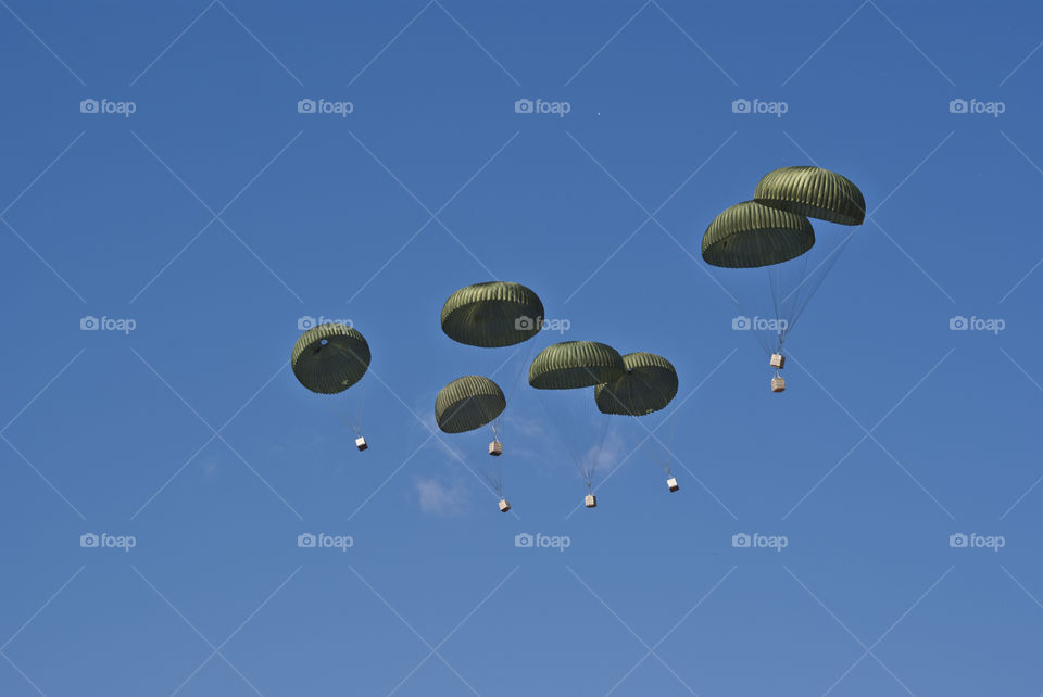 Parachutes falling from the sky containg some supplies