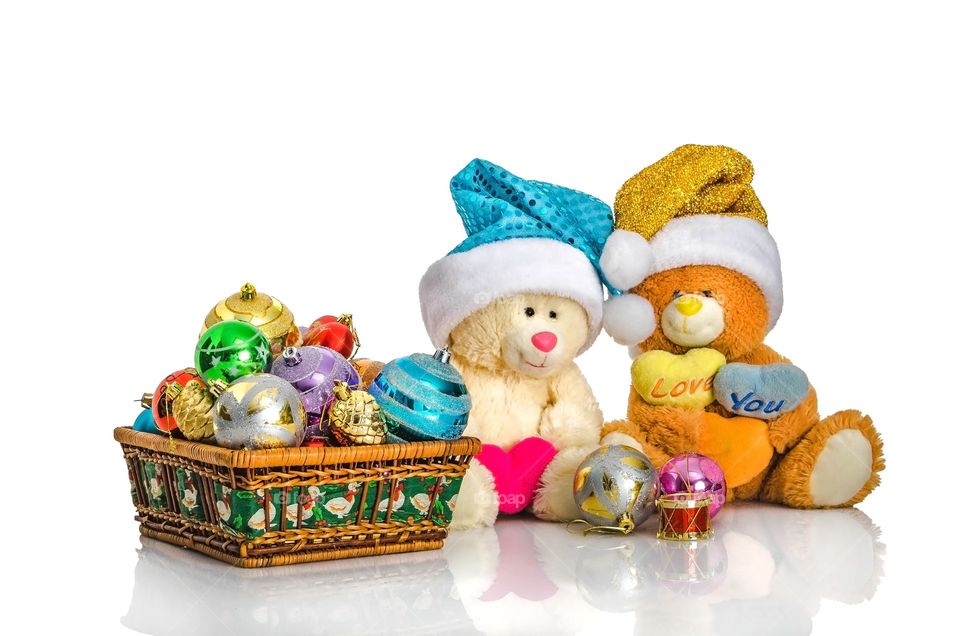 Basket with Christmas toys and bears on white isolated background.