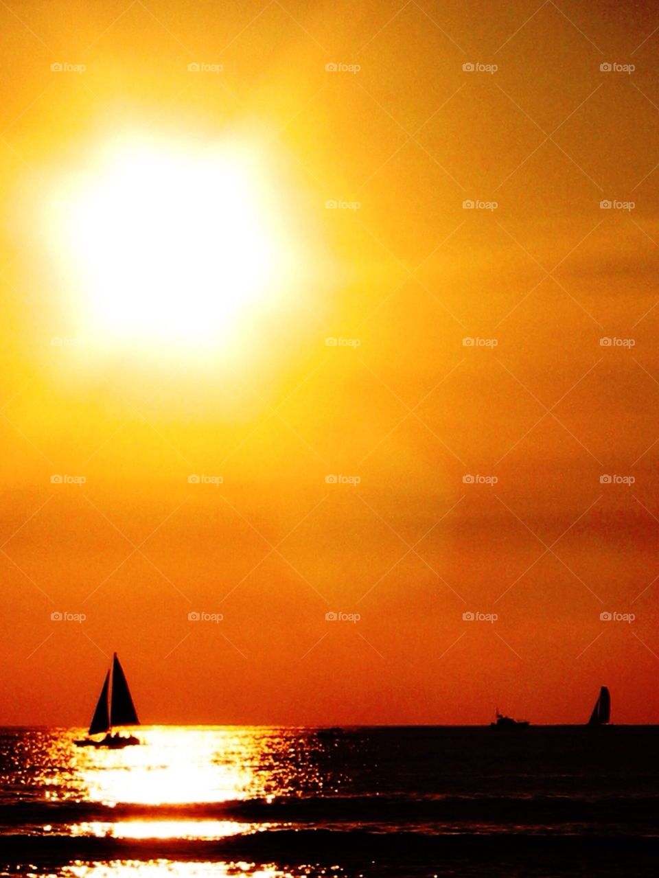 Silhouette of sailboat at sunset