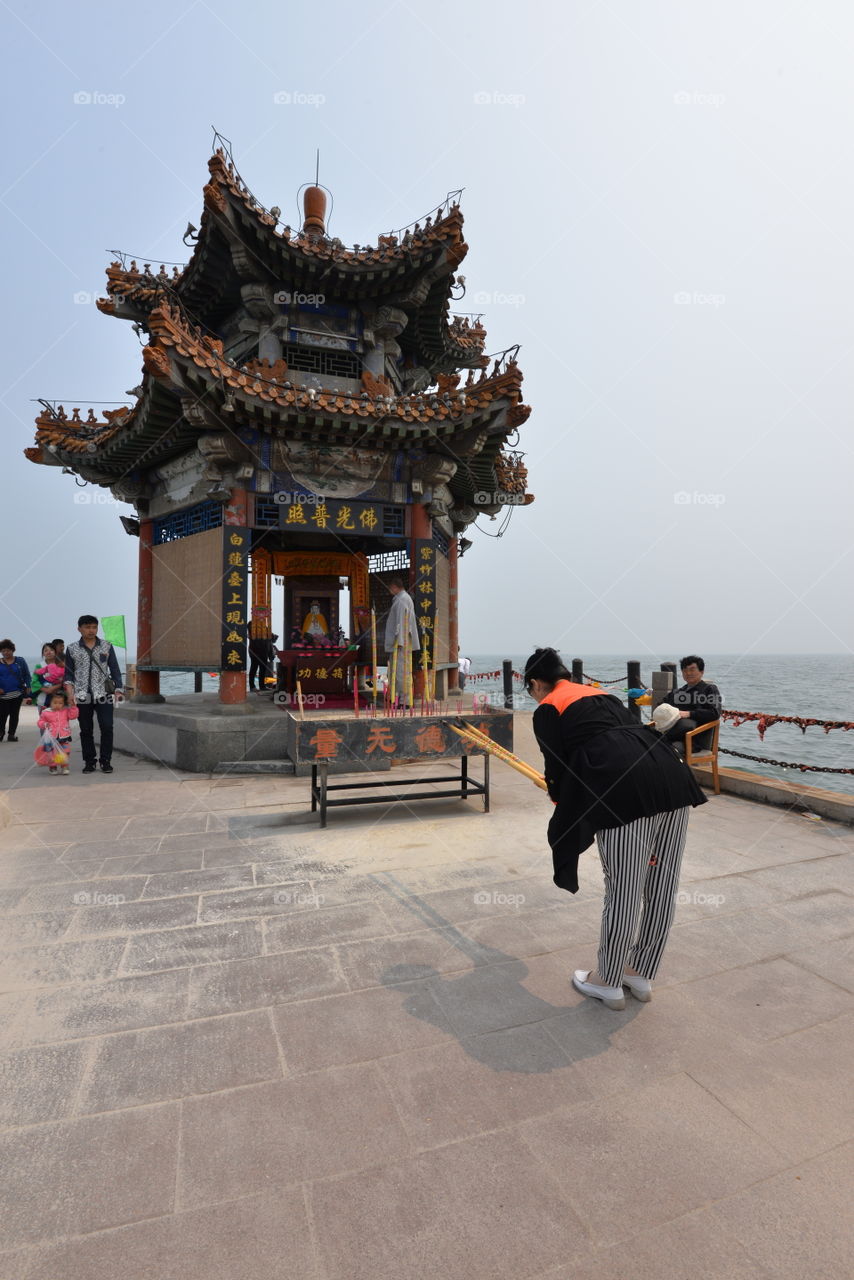 Asia China pray woman at a temple by the seaside