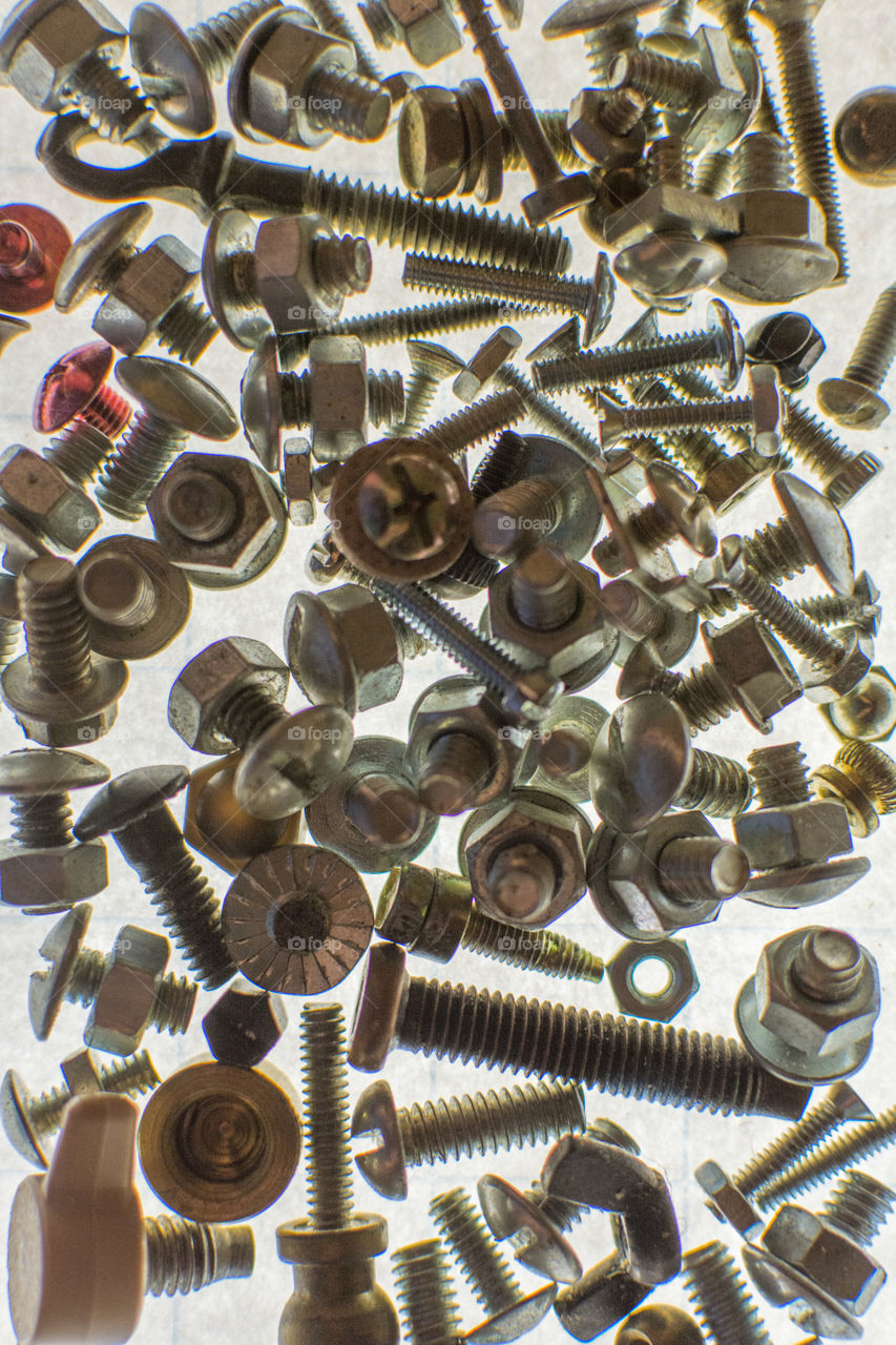 A backlit pile of bolts