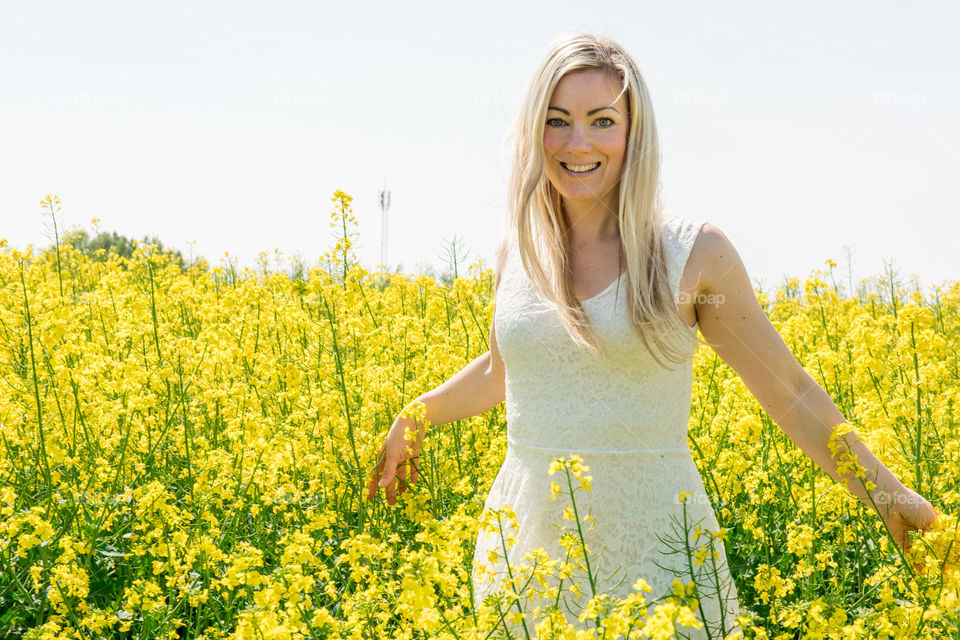 Woman 30 years old walking in a Raps field outside Malmö in Sweden.