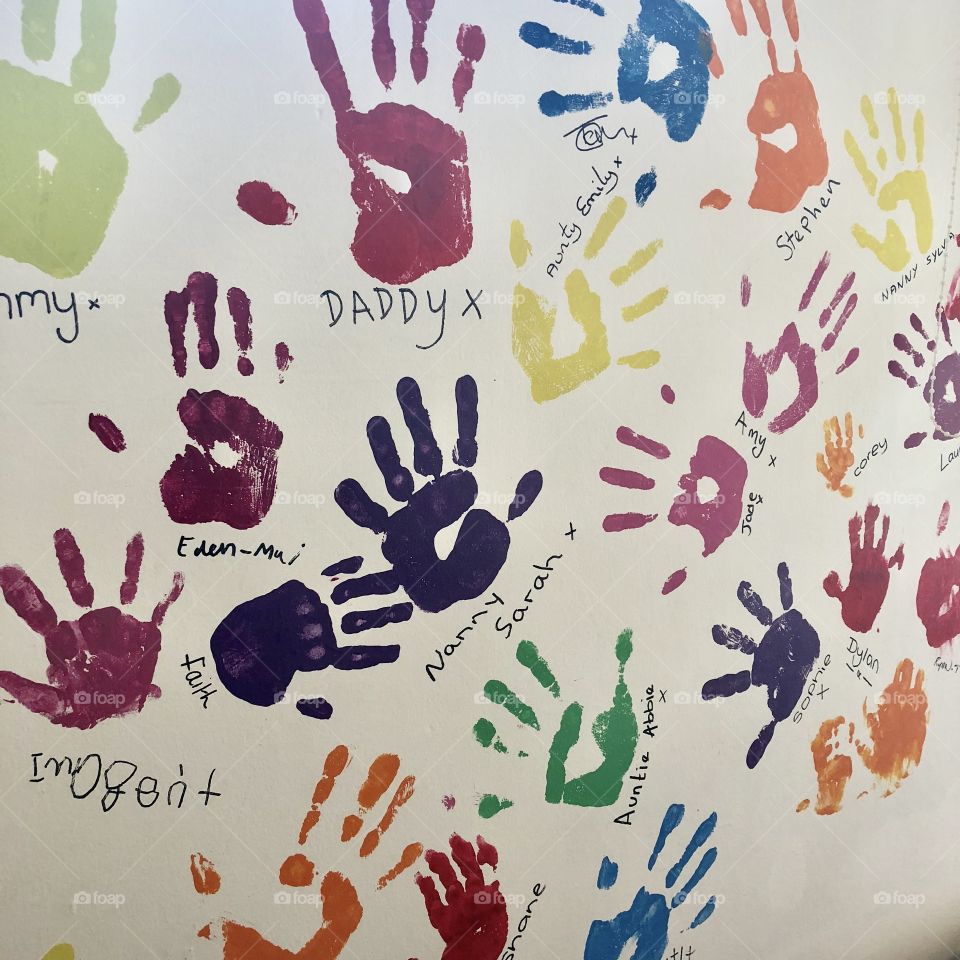 Colourful and bright Painted handprints on white wall