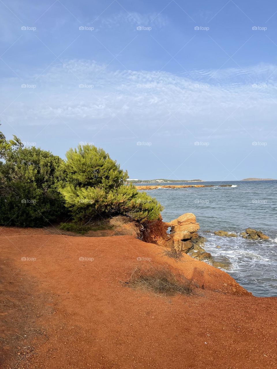 Red sand and sea view in Santa Eulalia des Riu, Ibiza, Spain 