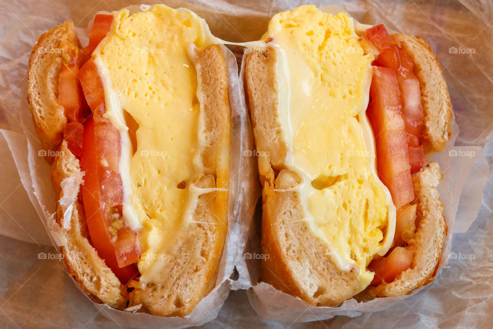 Egg cheese and tomato bagel with cheese pull 