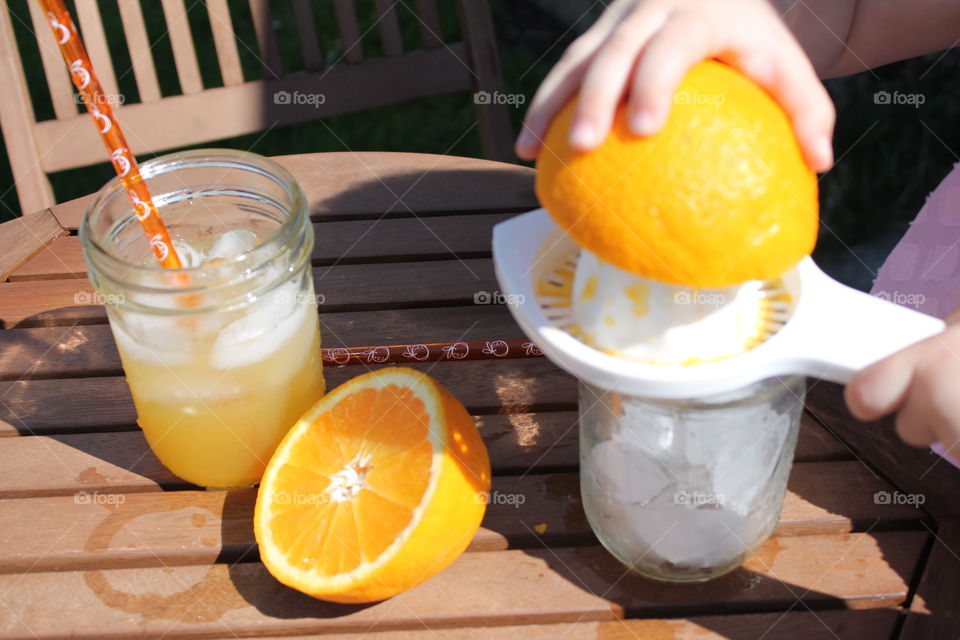 Human hand squeezing orange