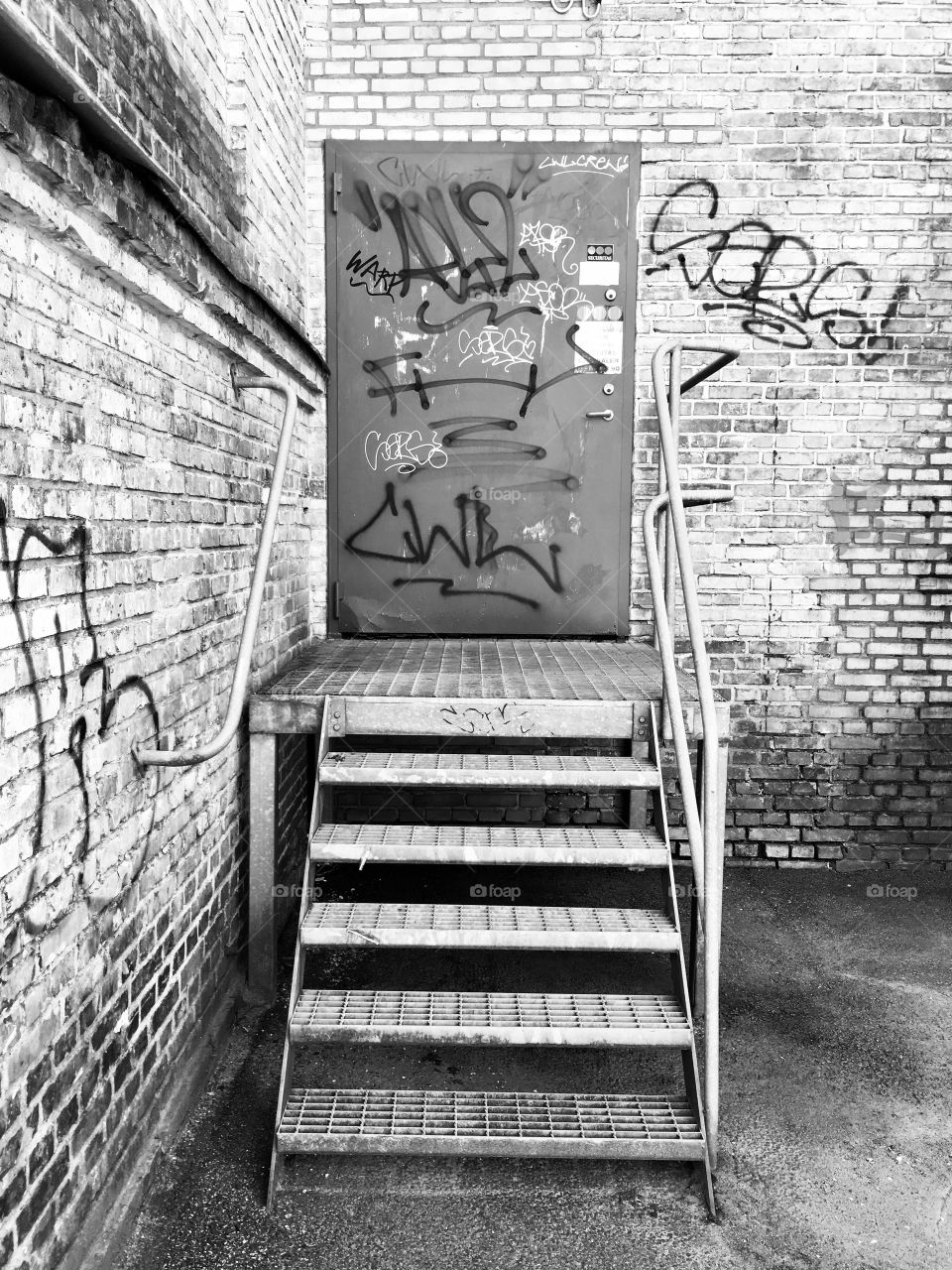 Industrial meal steps with dirty metal door and grafiti