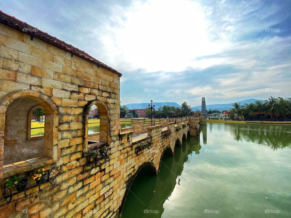 Brick bridge over the swamp with blue sky.