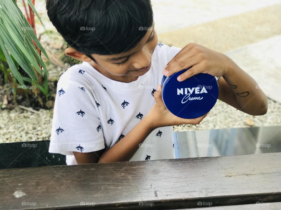 Boy showing a Nivea cream.