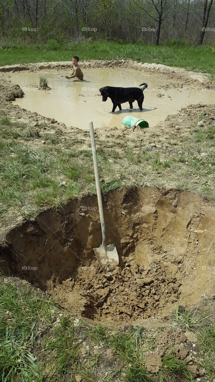 digging a pond while the dog and boy plays