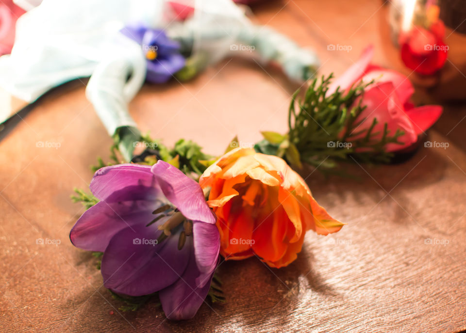 Symbolic flowers of different colors in harmony on rainbow flower crown decorative garland with taffeta blue ribbon 
