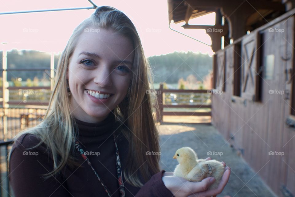 Blonde girl holding baby chick 