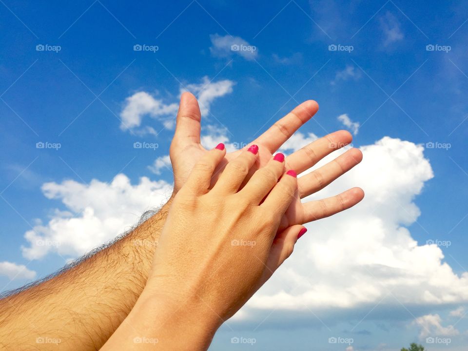 Her hand against his hand towards the sky