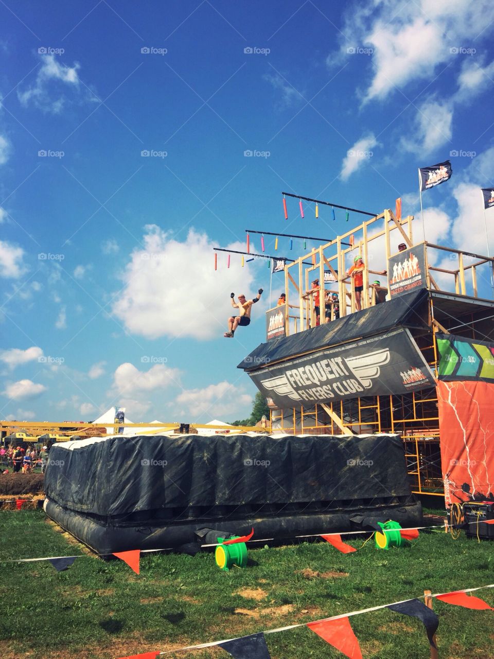 A man jumping from an obstacle in the Tough Mudder race.