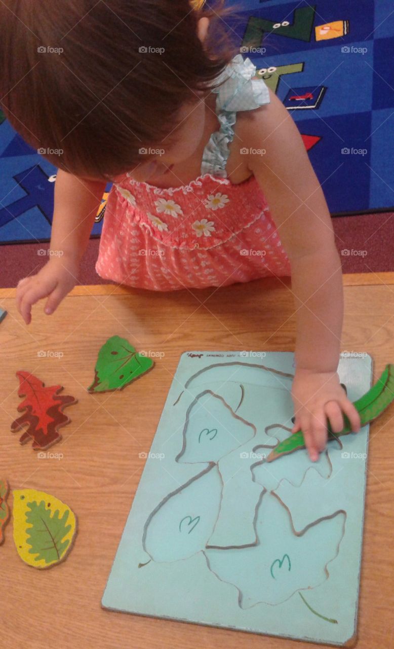 toddler learning how to complete puzzles with an autumn leaf version.