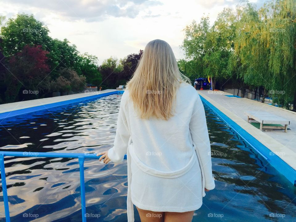 Rear view of woman standing against swimming pool