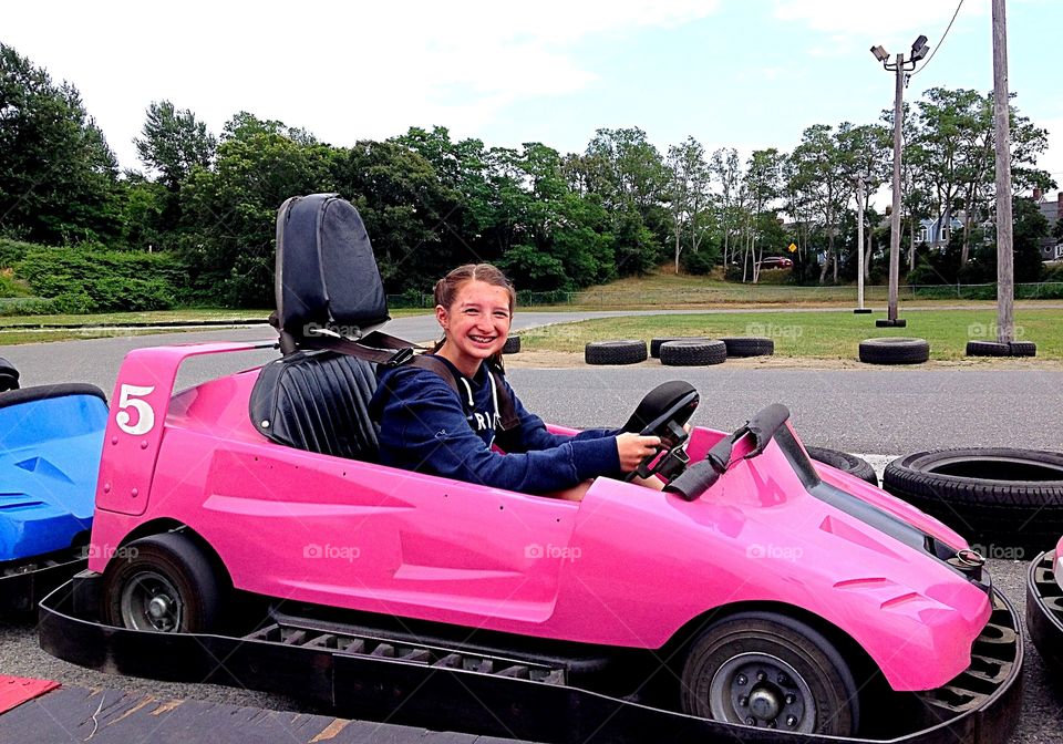 Smiling sitting in pink car on road