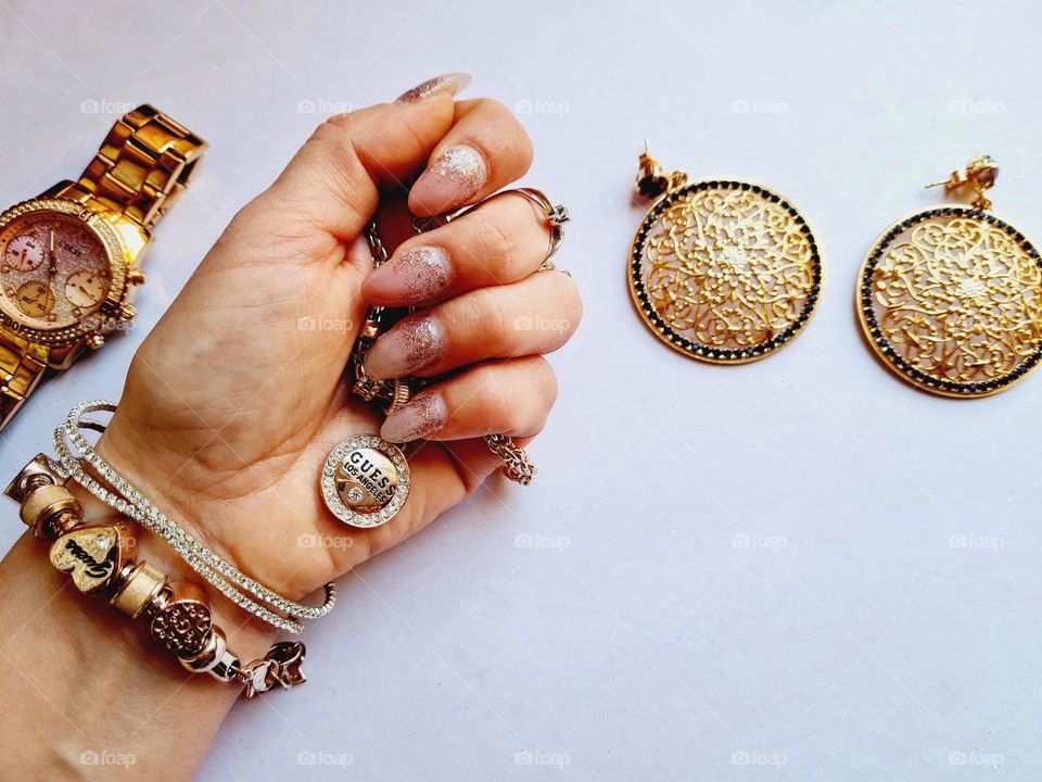 female hand squeezes golden bijouterie jewelry