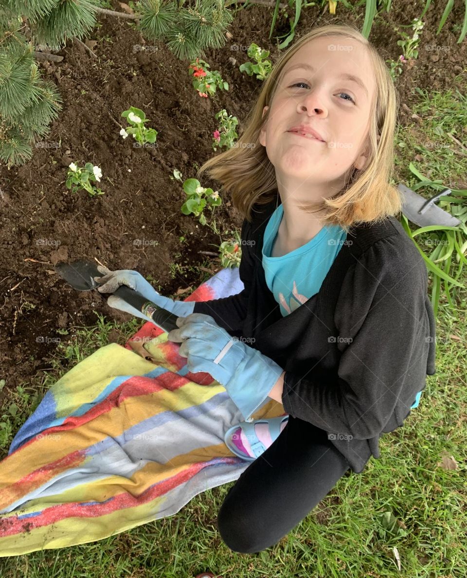 Girl planting flowers celebrating Earth Day!