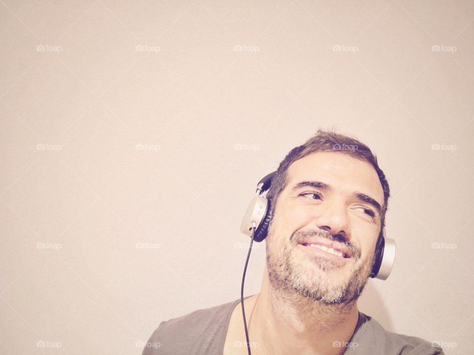 Man smiling while listening to music with headphones